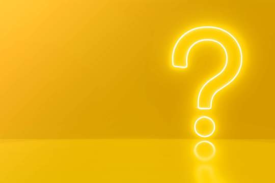 a neon question mark on a yellow background